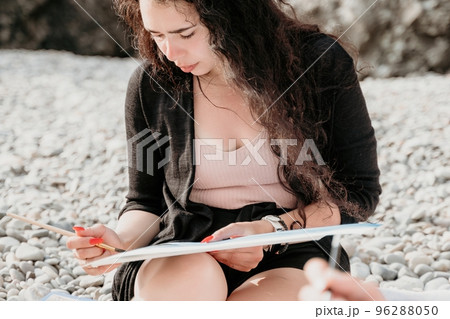 Woman holding her own sea beach scenery watercolor painting. Amateur painter. Creative female artist drawing the picture at the beach. Art, creativity and inspiration concept. 96288050