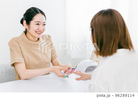 ネイルサロンでパーソナルカラー診断をするネイリストとアジア人女性 96289114
