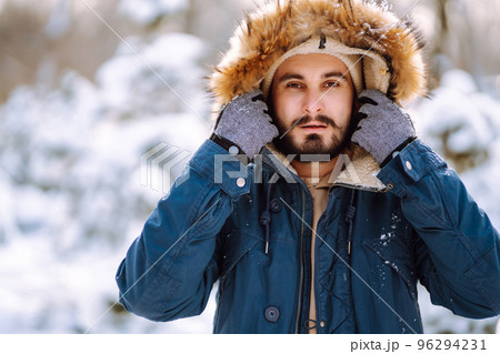 Portrait of young man in snowy winter forest. Season, christmas, travel and people concept. Portrait of young man in snowy winter forest. Season, christmas, travel and people concept. 96294231