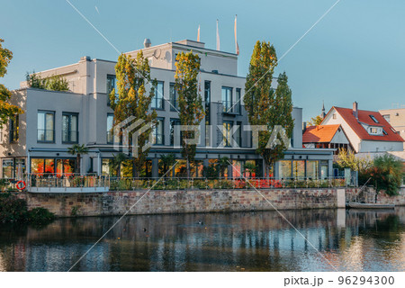 River On Sunset. Townhouses Buildings And Multi-floor Home At Waterfront. Sunset On River In City. Suburb Houses And Residential Building Near River In Europe. House In Nature On Shore On Sunset. 96294300