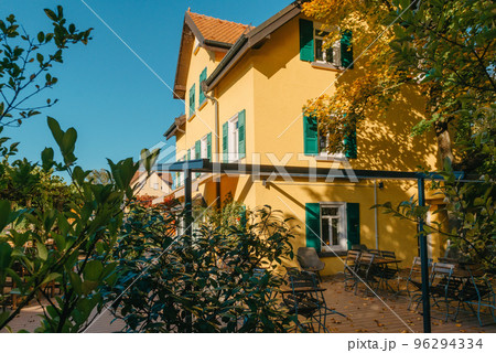 Image of a empty coffee tables arranged in backyard of a house. Autumn in Germany, Europe. Outdoor table in street cafe. autumn outdoor cafe wooden furniture old europe. Autumn photo of old-fashioned Image of a empty coffee tables arranged in backyard of a house. Autumn in Germany, Europe. Outdoor table in street cafe. autumn outdoor cafe wooden furniture old europe. Autumn photo of old-fashioned 96294334