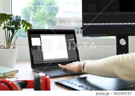 Cropped shot of female freelancer working editing video footage with professional computer at her workstation 96294537