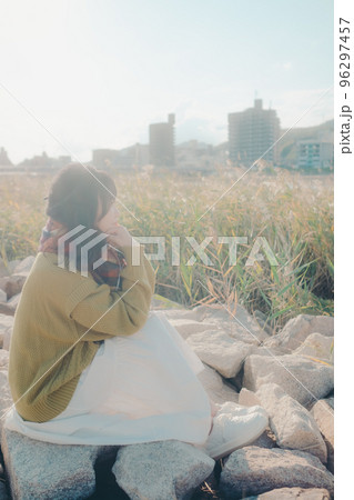 河川敷に音楽を聴きながら佇む若い女性の写真 河川敷に音楽を聴きながら佇む若い女性の写真 96297457