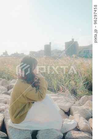 河川敷に音楽を聴きながら佇む若い女性の写真 河川敷に音楽を聴きながら佇む若い女性の写真 96297458