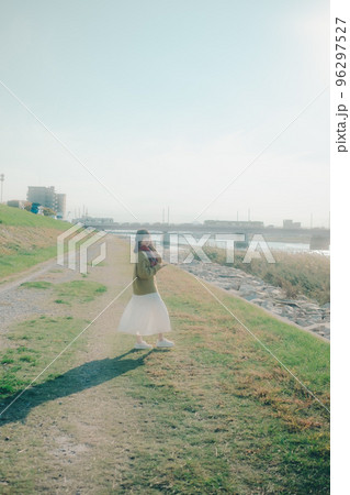 河川敷に音楽を聴きながら散歩をする若い女性の写真 96297527
