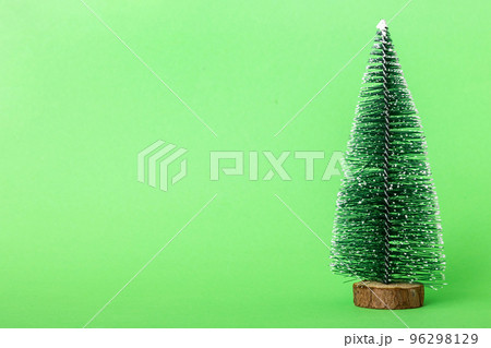 One small Christmas tree on colored background. new year decoration with copy space One small Christmas tree on colored background. new year decoration with copy space 96298129