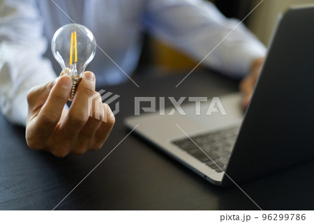 光る電球を持つ手アイディアやエネルギー holding a light bulb for ideas 96299786