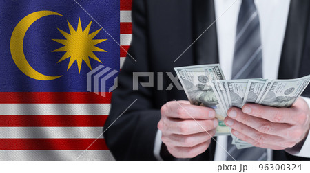 Hands holding dollar money on flag of Malaysia 96300324