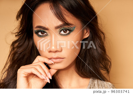 Portrait of serious confident asian woman looking to camera on beige background closeup 96303741