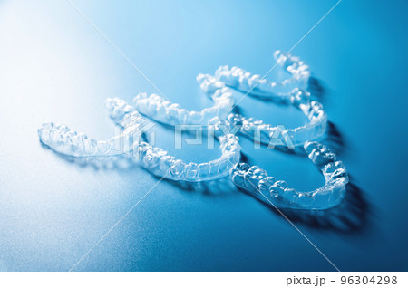 transparent straighteners for teeth in the shape of a pyramid on a blue background, dentistry and orthodontics. 3D printing in modern medicine transparent straighteners for teeth in the shape of a pyramid on a blue background, dentistry and orthodontics. 3D printing in modern medicine 96304298