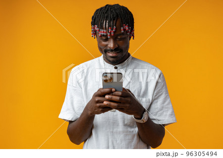 Young african man using smartphone over isolated yellow background 96305494