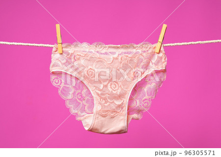 Female panties hanging on rope against pink studio background 96305571