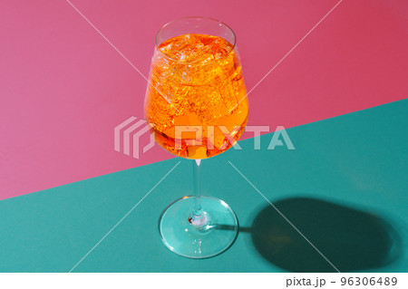 Glass of fresh cocktail on color background Glass of fresh cocktail on color background 96306489