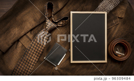 Men's necktie and accessories on Brown background with chalkboard with place for text. Men's necktie and accessories on Brown background with chalkboard with place for text. 96309484