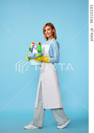woman in rubber gloves and cleaner apron with cleaning supplies 96310295