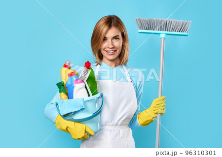woman in gloves holding bucket of detergents and broom woman in gloves holding bucket of detergents and broom 96310301