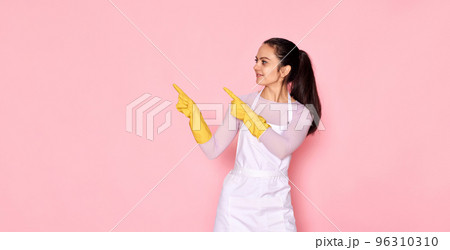woman in rubber gloves pointing fingers aside at copyspace 96310310