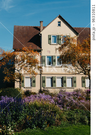 House with nice garden in fall. Flowers in the City Park of Bietigheim-Bissingen, Baden-Wuerttemberg, Germany, Europe. Autumn Park and house, nobody, bush and grenery 96310811