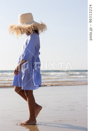 Cute little girl in hat and dress on beach 96313214