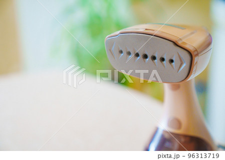 close up. Working portable hand steamer for clothes. steam for ironing clothes. 96313719