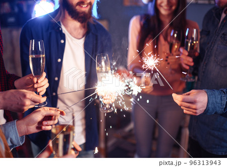 Group of happy people holding sparklers at party. Young people celebrating New Year together. Group of happy people holding sparklers at party. Young people celebrating New Year together. 96313943