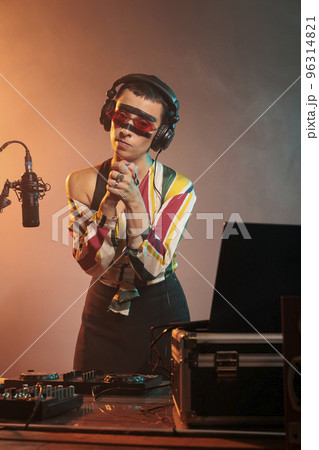 Disc jockey doing prayer hands symbol and begging for hope and fortune, praying and asking for luck at mixing show. Preparing to use turntables to produce music, expressing faith. Disc jockey doing prayer hands symbol and begging for hope and fortune, praying and asking for luck at mixing show. Preparing to use turntables to produce music, expressing faith. 96314821