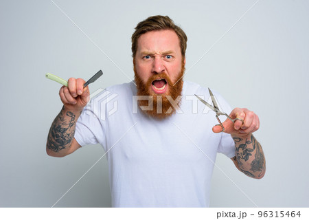 Aggressive man with scissors and blade is ready to cut the beard 96315464