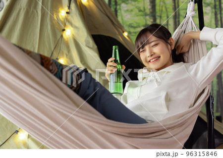 お家時間　ハンモックでくつろぎながらビールを飲む女性 96315846