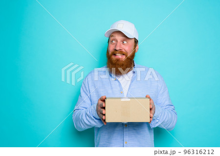 Courier with carton box in hand is surprised about something 96316212
