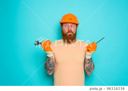 Worker with yellow hat is confused about his work Worker with yellow hat is confused about his work 96316236