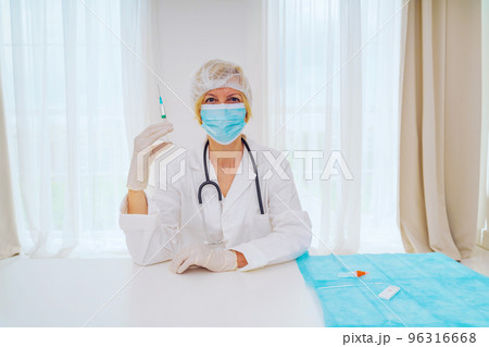 doctor with mask and syringe is ready to administer the vaccine against covid 19 96316668