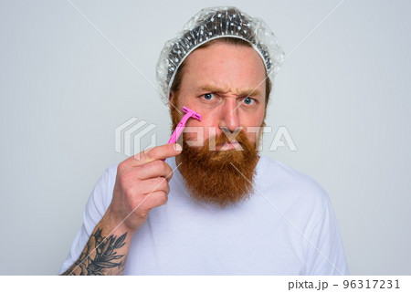 Man adjust the beard with a razor blade 96317231