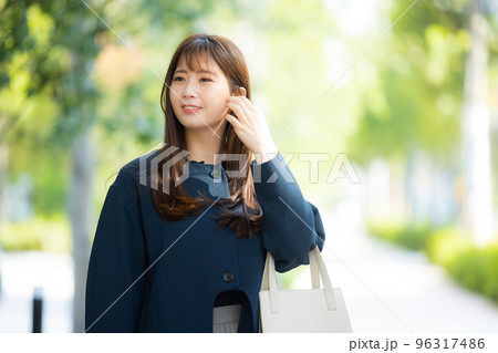 屋外を歩くコートの女性 屋外を歩くコートの女性 96317486