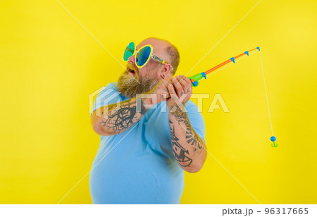 Fat man with beard and sunglasses have fun with the fishing rod 96317665
