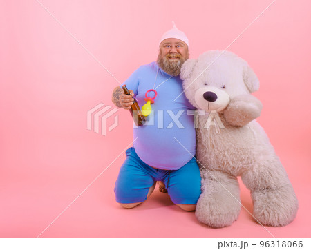 Fat happy man acts like a happy baby but drinks beer Fat happy man acts like a happy baby but drinks beer 96318066