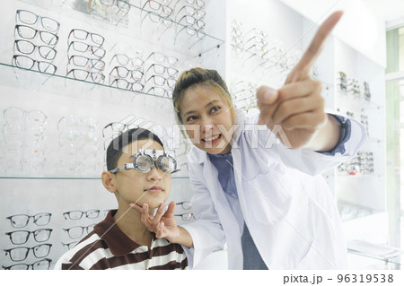 Young boy examining eyesight in optical clinic. Young boy examining eyesight in optical clinic. 96319538