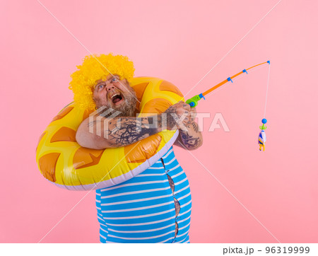 Fat stressed man with wig in head plays with the fishing rod 96319999