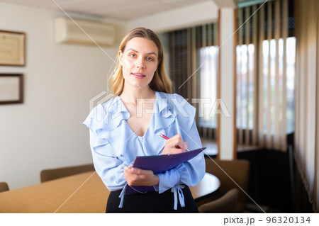 Portrait of woman holding folder in hands Portrait of woman holding folder in hands 96320134