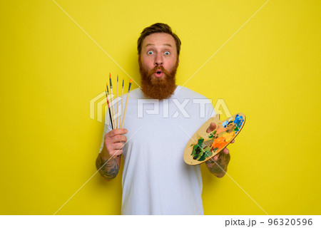 Wondered man with beard and tattoo is ready to draw with brushes 96320596