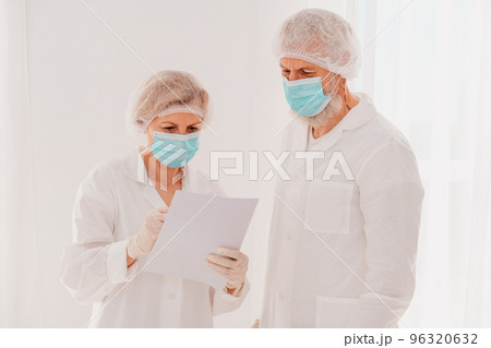 Doctors with face mask work together in hospital 96320632