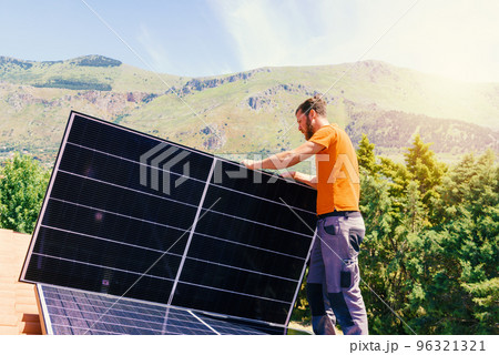 Workers assemble energy system with solar panel for electricity and hot water 96321321