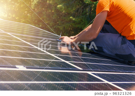 Workers assemble energy system with solar panel for electricity and hot water 96321326