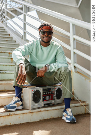 Young black man wearing street style clothes with boombox 96325684