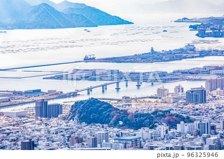 広島廿日市大橋と宮島、廿日市市、五日市の港湾部を展望しています。手前に海老山町の森が見えます。 96325946