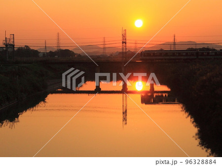 夕暮れ時に鉄橋を渡る近鉄橿原線の電車 96328884