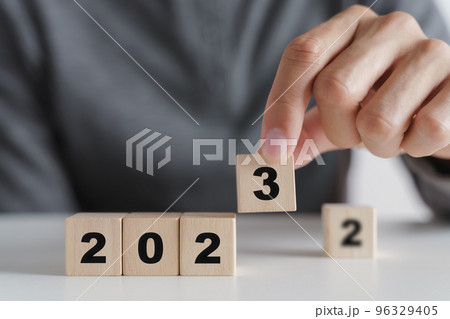 Man hand putting wooden cube block to change 2022 year to 2023 year. start to year 2023. happy new years concept. 96329405