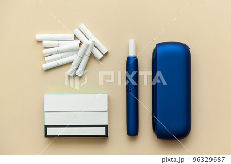 Iqos electronic blue cigarette on a beige background. Iqos electronic blue cigarette on a beige background. 96329687