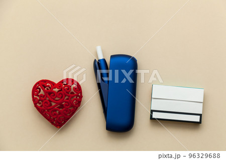 Iqos electronic blue cigarette on a beige background. Iqos electronic blue cigarette on a beige background. 96329688