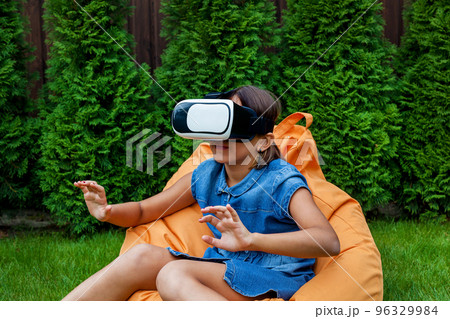 Girl with virtual reality glasses in the park Girl with virtual reality glasses in the park 96329984