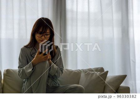 パジャマ姿でスマホを操作する若い女性　手元にフォーカス 96330382